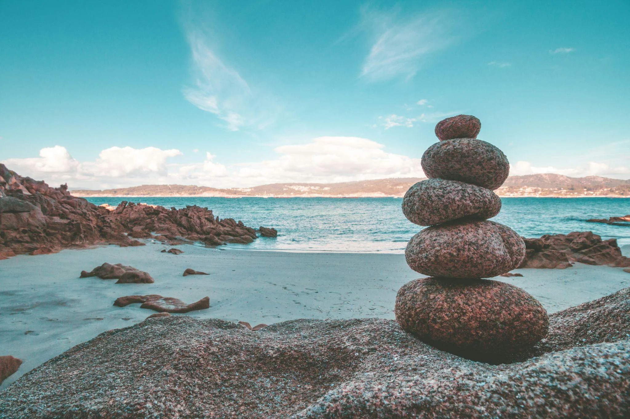 Balanced stones beside a peaceful turquoise sea